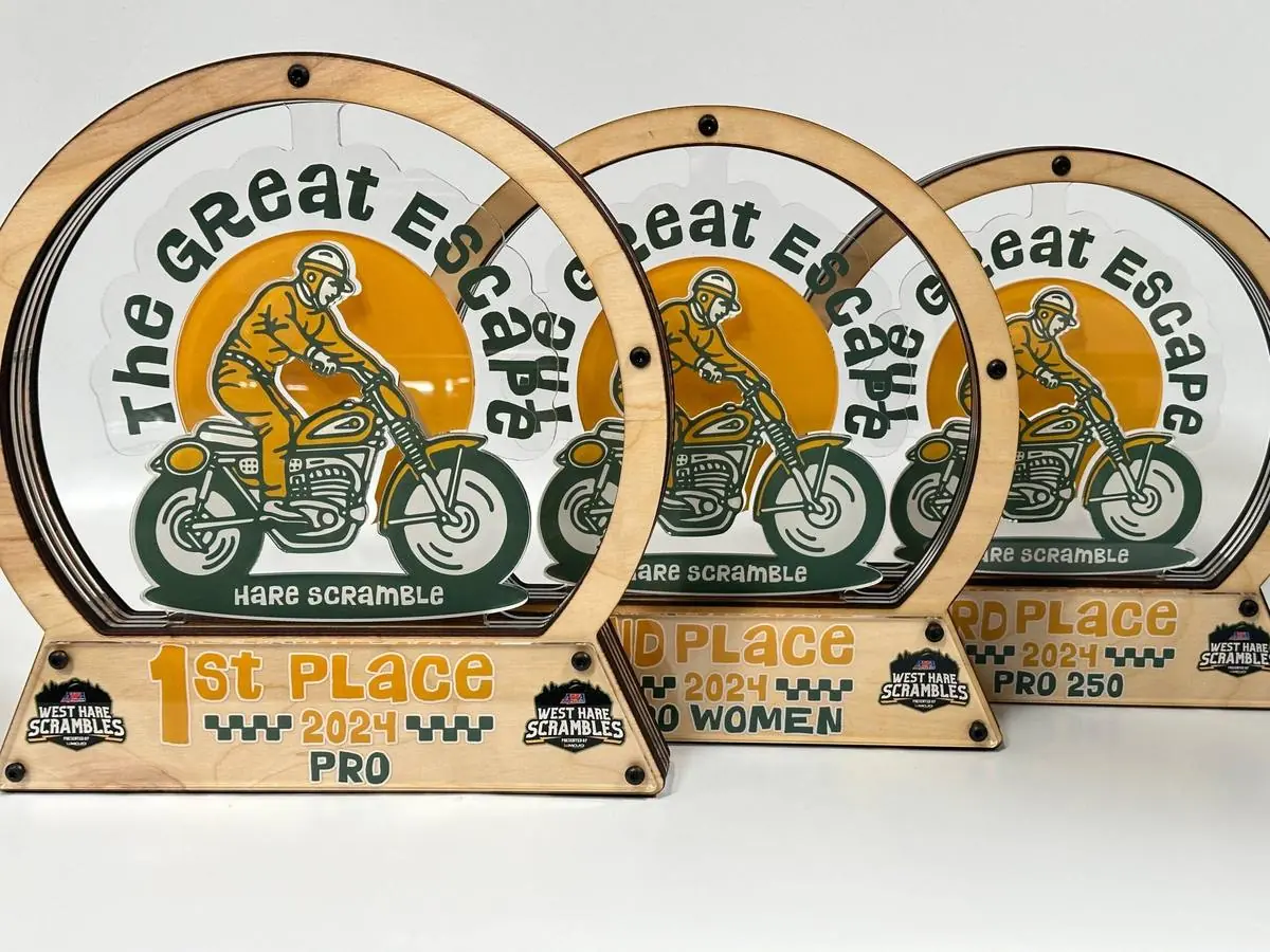 First, second and third place awards from an off-road event, each a printed acrylic disc inside a wood ring with a placing plate below