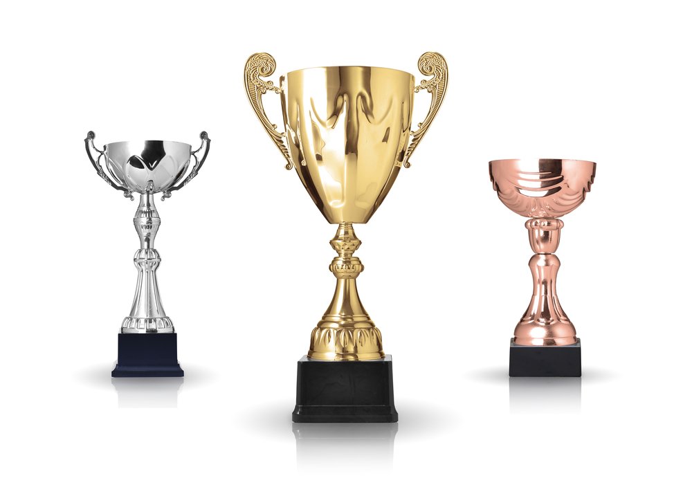 Silver, gold and bronze cup trophies in three sizes on black bases