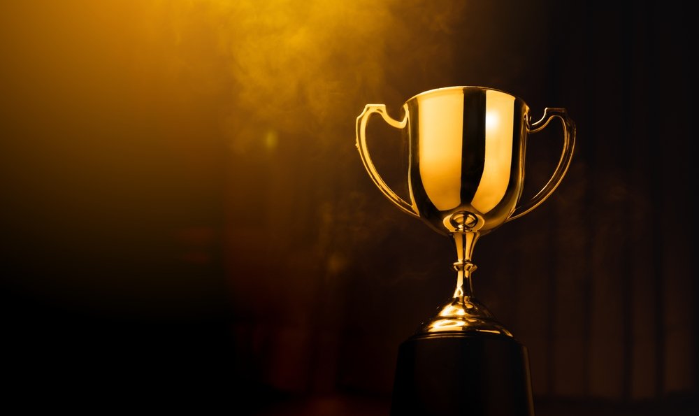 Gold cup trophy lit against a dark background