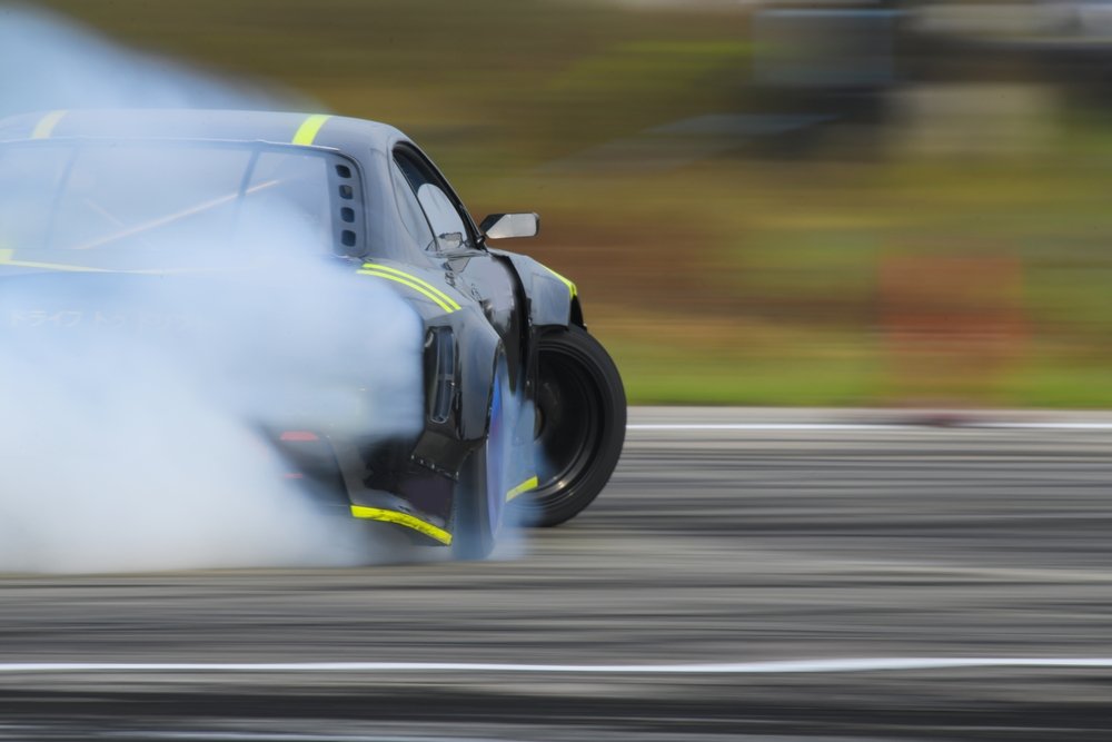 Drift car sliding through a corner in a cloud of tyre smoke
