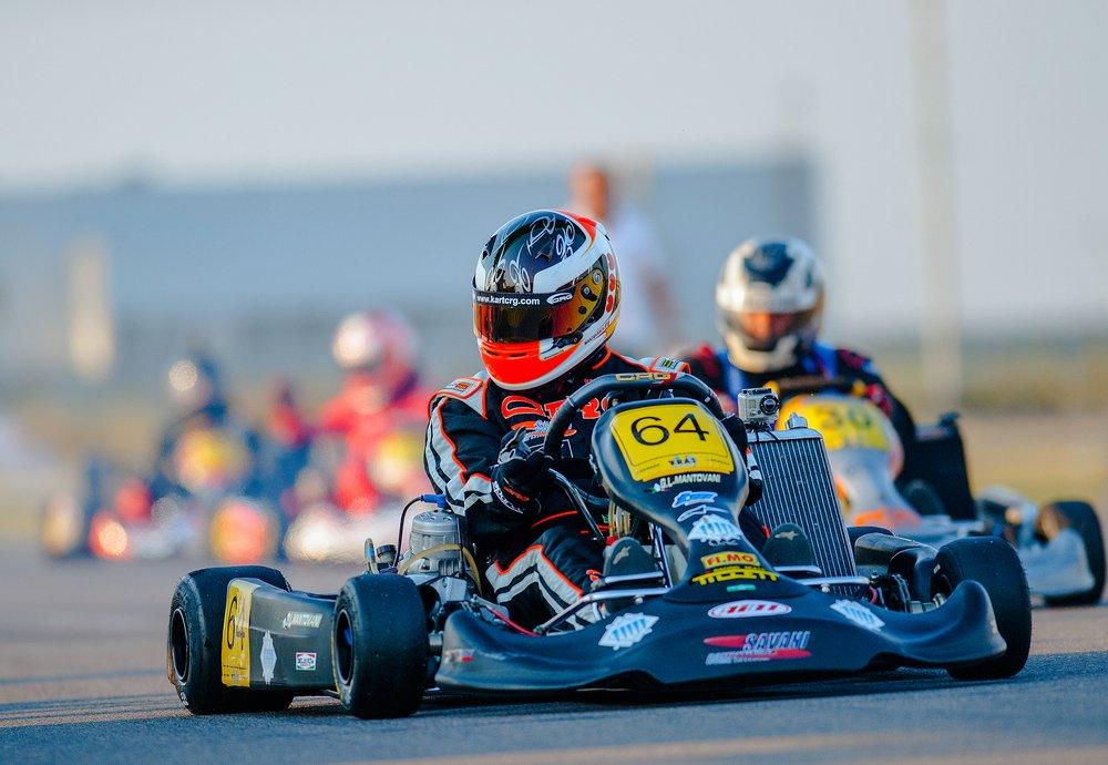 Bucharest,,Romania,-,August,4:,Unknown,Pilots,Competing,In,National Kart racer in a helmet driving kart number 64 with other karts following on track