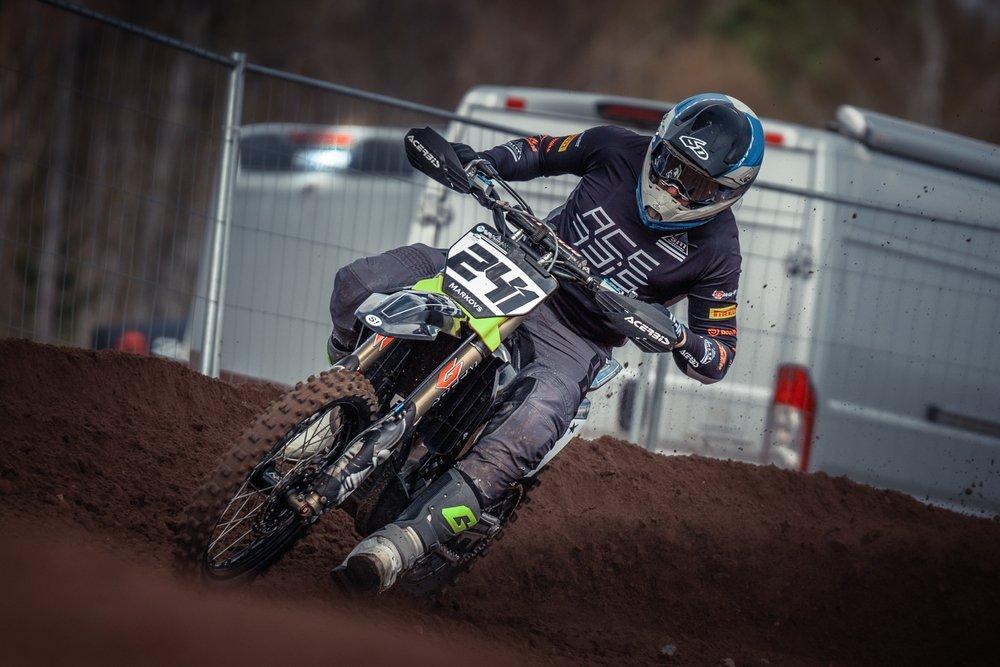 Latvia,,Staicele,,26-04-2025,A,Person,Wearing,A,Helmet,,Gloves,,Clothes, Motocross rider leaning through a bermed dirt corner on a race bike